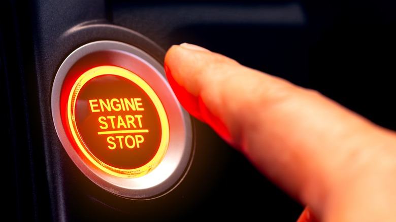 Finger about to push an engine start button