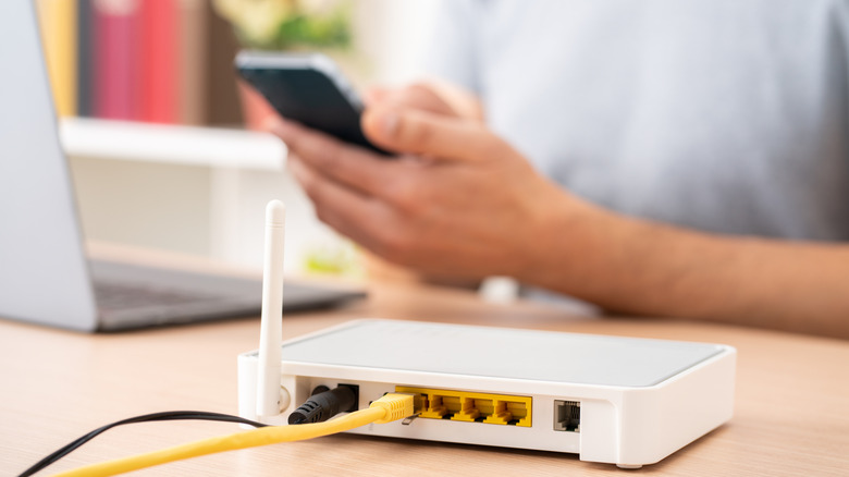 router hub in foreground, woman on a phone in background