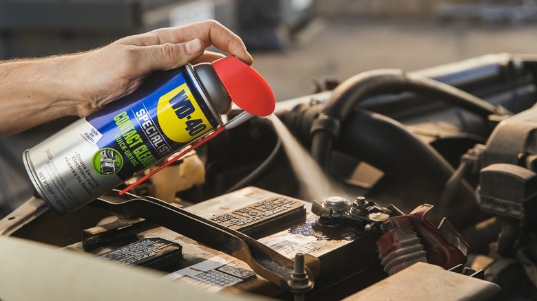 person using WD-40 Specialist Electrical Contact Cleaner on car battery