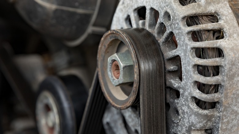 A closeup image of an engine drive belt and alternator