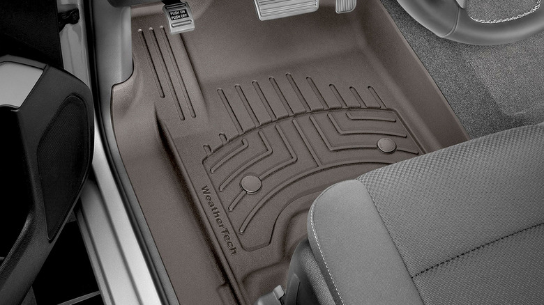 WeatherTech Floor Mat installed at driver's feet with clutch, brake, and gas pedals visible