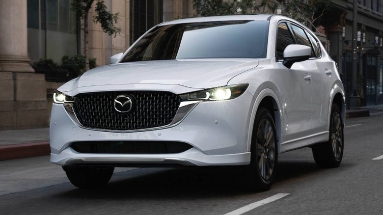 White Mazda CX-5 driving down a road