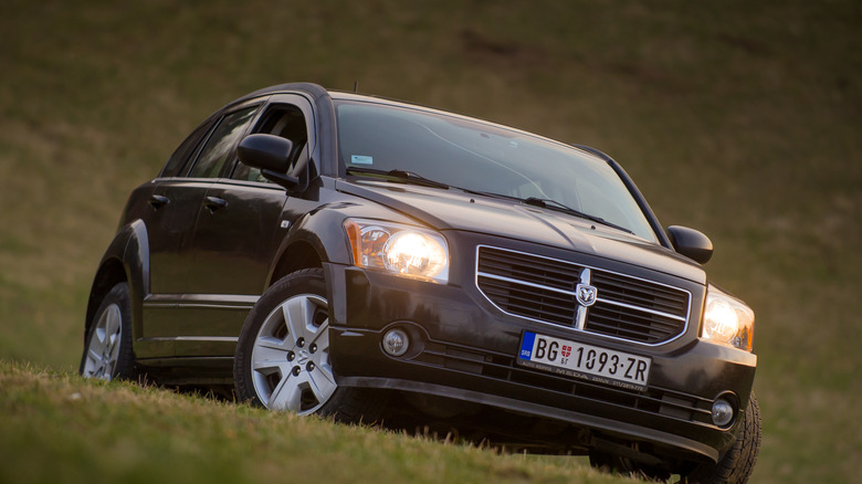 A Dodge Caliber in black on a hill, front 3/4 view