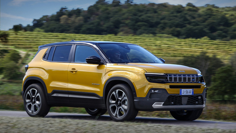 A Jeep Avenger on the move in yellow, front 3/4 view