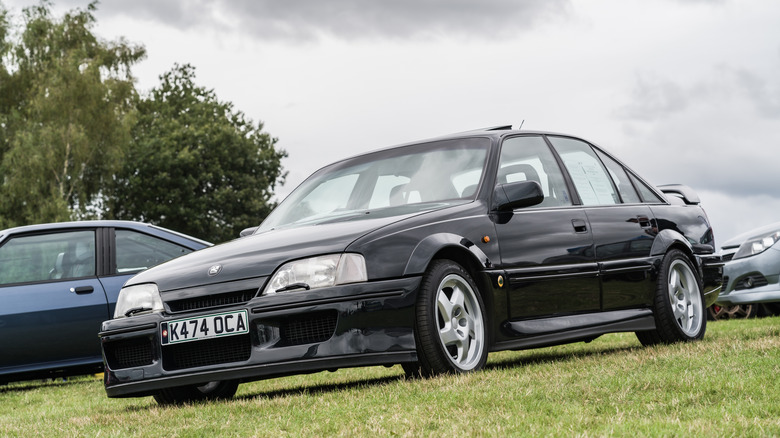 The Lotus Carlton at an open-air auto show, front 3/4 view