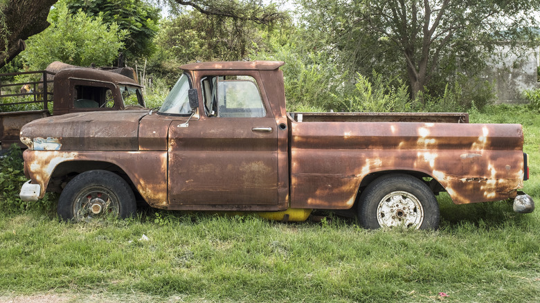 Rusty pickup truck in field