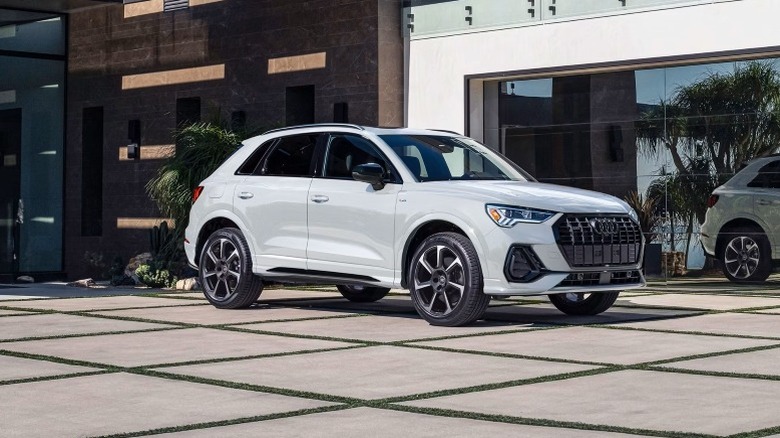 White 2025 Audi Q3 parked on concrete floor in front of a building