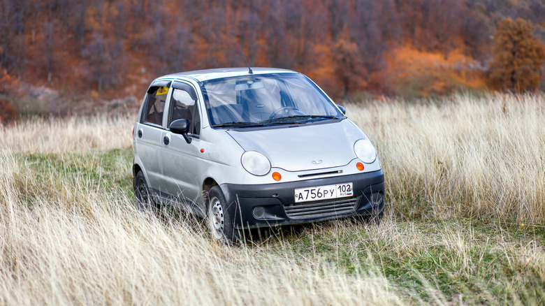 A gray Daewoo Matiz in a field