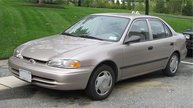 A beige Chevy Prizm parked on a street