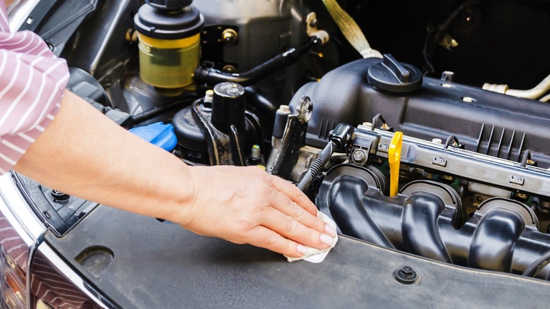 Person cleaning up engine bay