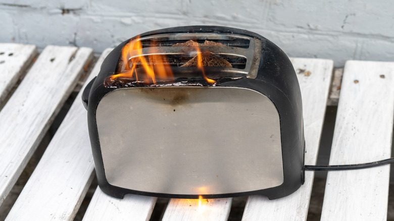 Toaster that's on fire and beginning to melt.