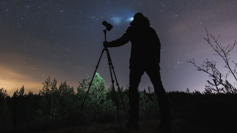 Photographer using a tripod for night photography