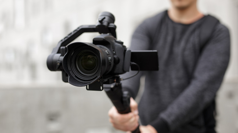 Man holding DSLR camera on 3-axis gimbal