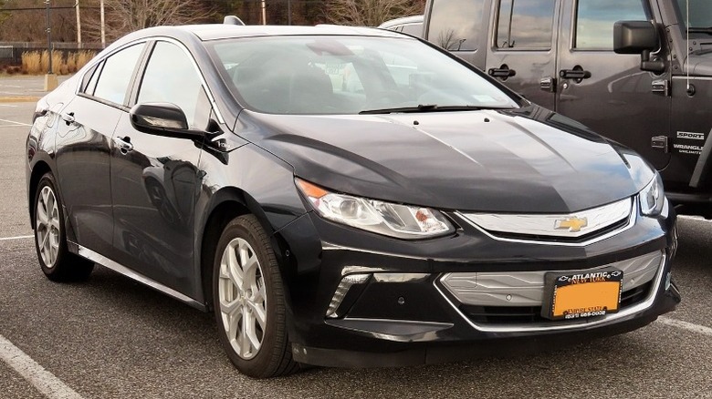 Black second-generation Chevrolet Volt parked in an outdoor parking lot with trees in the background