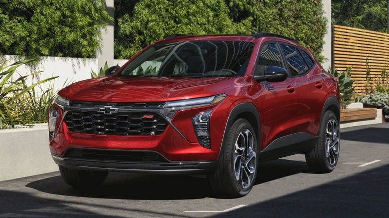 2025 Chevy Trax parked on a paved surface next to a white fence at daytime