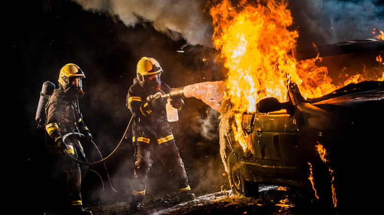 Firefighters extinguishing a car fire