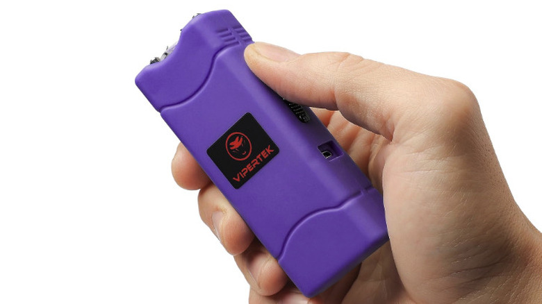 Vipertek stun gun in purple with someone's thumb on the trigger