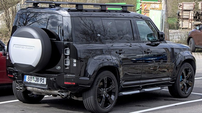 A black Land Rover Defender in a parking lot.