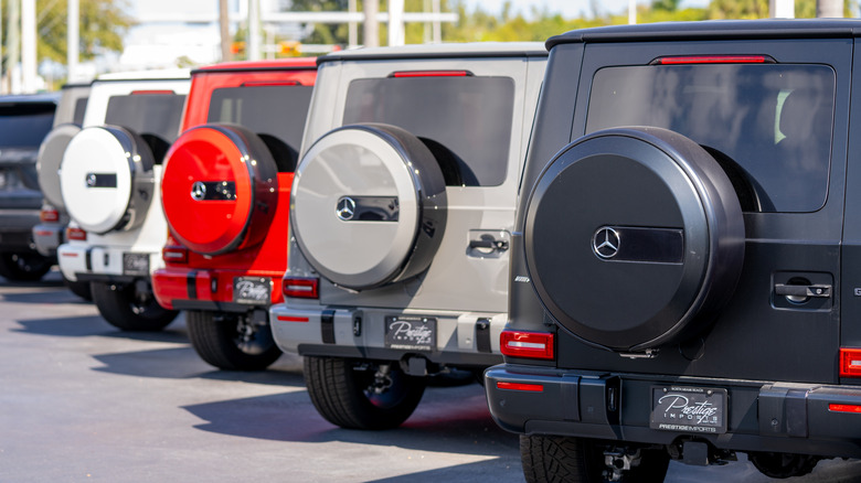 A series of Mercedes-Benz G-Class vehicles in a parking lot.