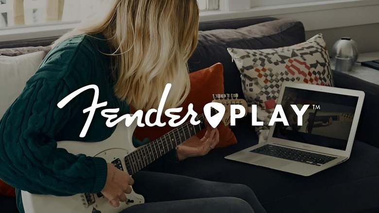 Woman playing guitar on couch