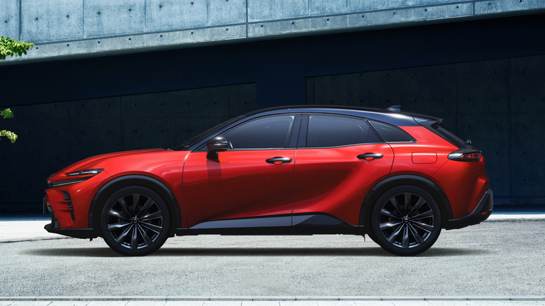 The side profile of the Toyota Crown Sport in red, black wheels