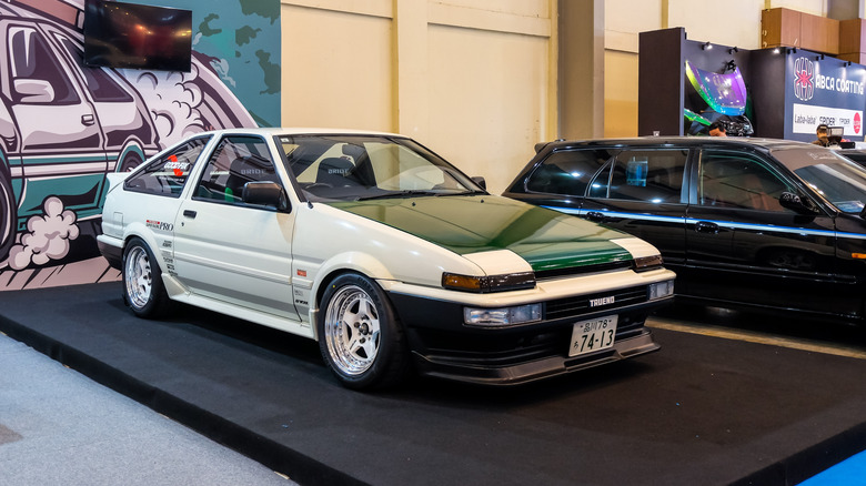 A modified Toyota Sprinter Trueno AE86 at a car show, front 3/4 view