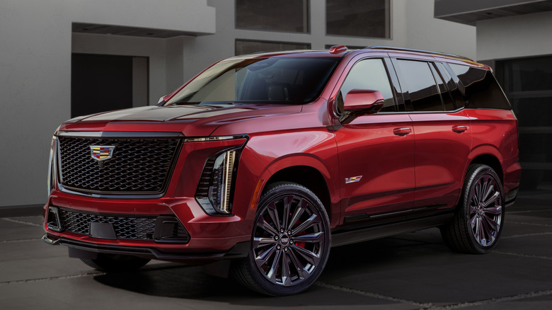 red 2025 Cadillac Escalade-V parked next to white house