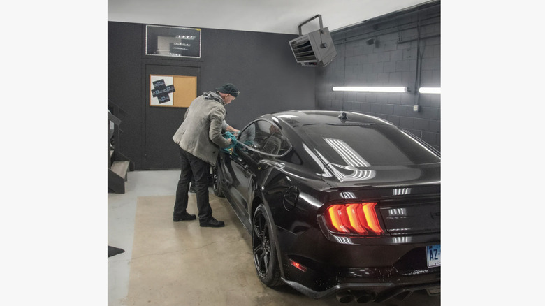 Comfort Zone 7,500-watt Ceiling-Mounted Garage Heater above a car and person