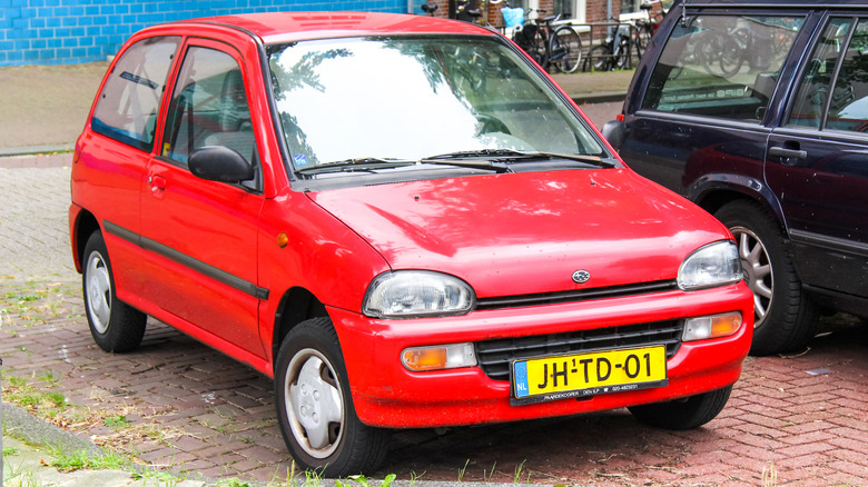 A street parked red Subaru Vivio, front 3/4 view