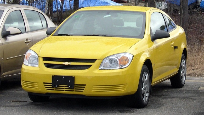 yellow 2006 Chevrolet Cobalt parked near grass