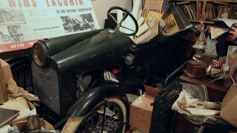 1914 Merz cycle car sitting amidst clutter inside a house in an episode of American Pickers.