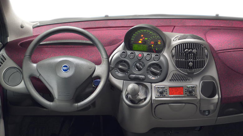 Dashboard of the Fiat Multipla (2002) showing steering wheel, high-mounted gearstick. tachometer, speedometer and other instruments.