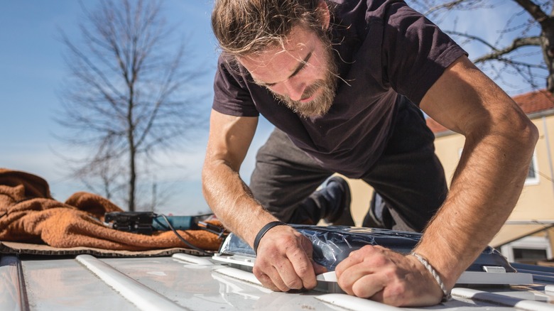 Man inspecting the roof of an RV