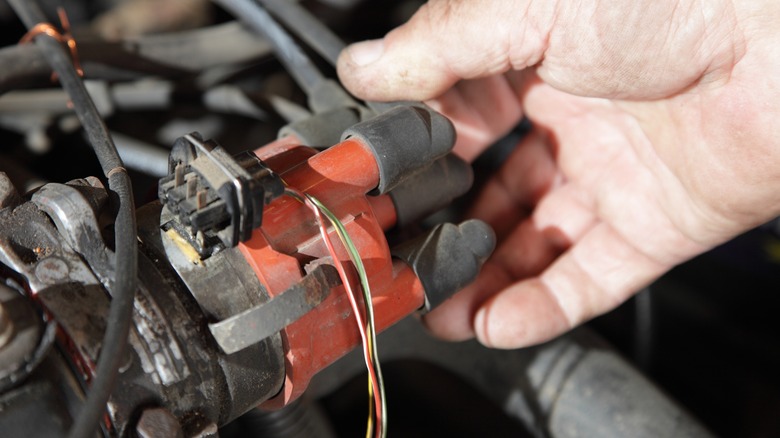 person inspecting distributor cap