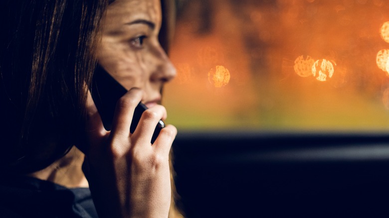 A woman talking on a phone in a car