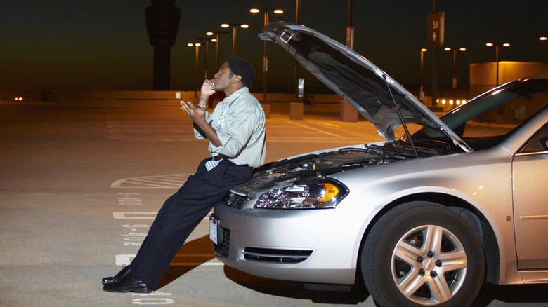 car owner sitting on open hood