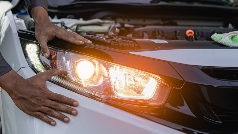 Hands inspecting headlights