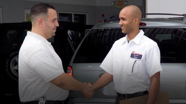 mechanic and customer shaking hands