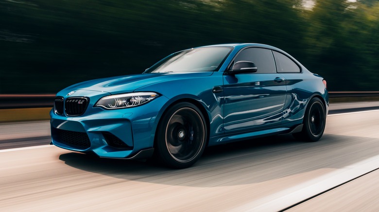 Blue BMW M2 driving on road