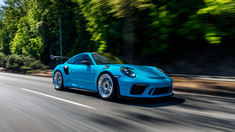 Blue Porsche 911 racing down street