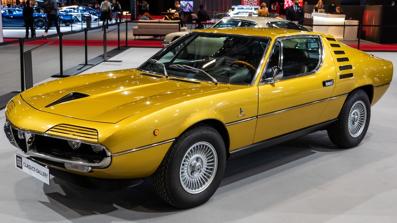 A yellow 1970 Alfa Romeo Montreal in a car show.