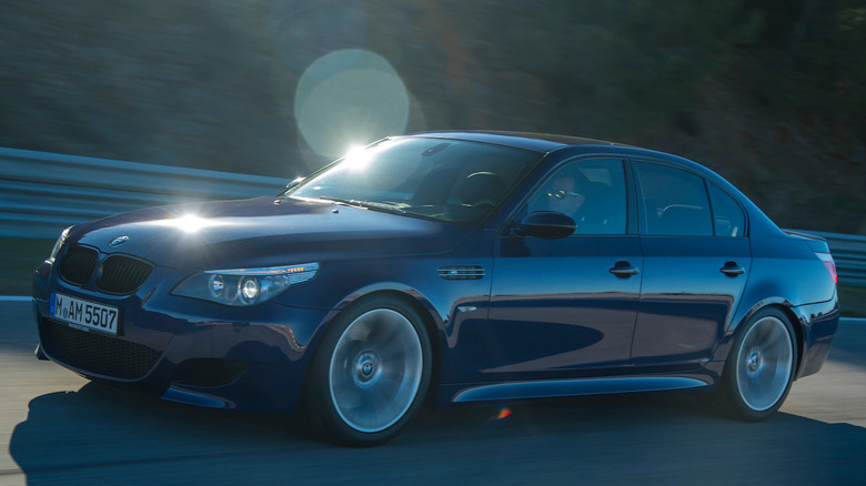 A BMW M5 driving on a sunny road.