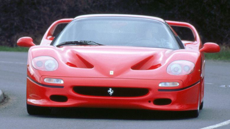 A Ferrari F50 driving on a winding road.