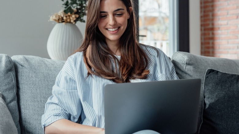 A woman using computer monitor and keyboard