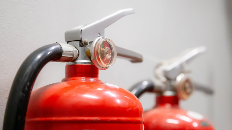 The top of two fire extinguishers in bright room