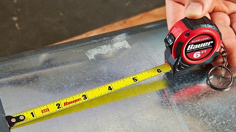 Tape measure being used on sheet of metal