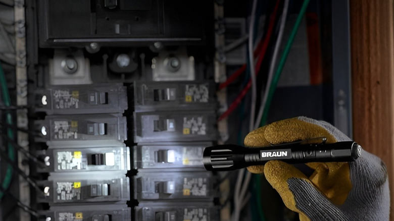 Looking at fuse box with flashlight