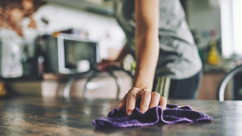 person cleaning kitchen table