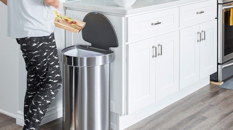 Woman throwing trash into simplehuman trash can