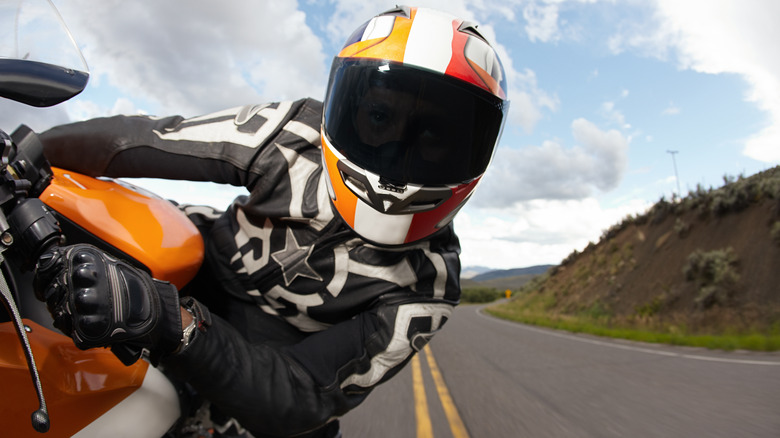 Man riding motorcycle on open road and leaning to the right